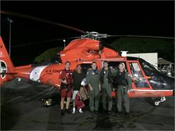 The captain from the 22-foot sailing vessel Harmony B stands with an MH-65 dolphin helicopter crew from Air Station Barbers Point, following their rescue off Molokai, Feb, 17, 2017. Coast Guard responded to a mayday call from the mariner that was made on VHF channel 16.(U.S. Coast Guard photo/Released)