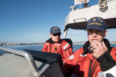 Seaman Christian Green, of Station Manasquan Inlet, made a radio call during training operations aboard a 47' Motor Lifeboat, while Petty Officer 3rd Class Vaugh Yarnall looks on, February 24, 2017. U.S. Coast Guard photo by Auxiliarist David Lau.